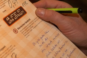 Flyer mit Gedicht, Hand mit Kugelschreiber